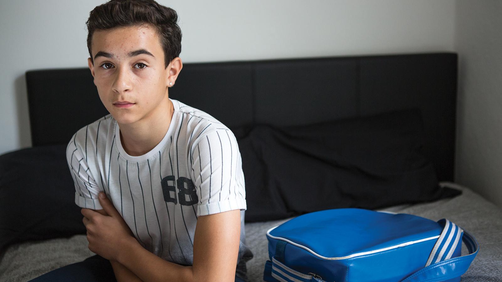 Boy with baseball shirt and blue bag