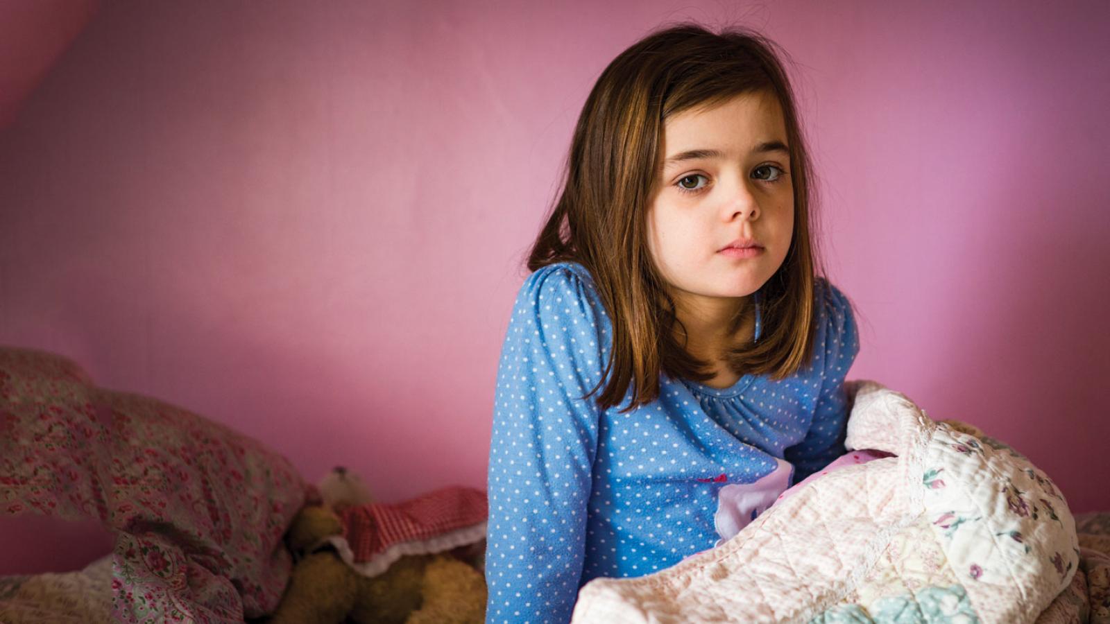 young girl sitting in bed